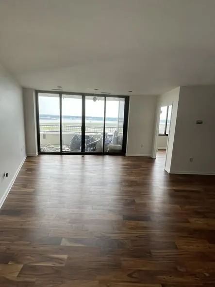 Waterfront condominium living room with new hardwood floors running to the balcony doors
